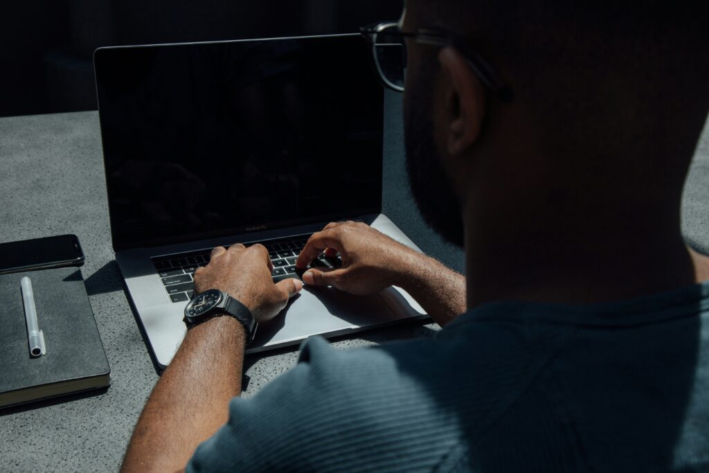 hands on a laptop with the persons back to the camera