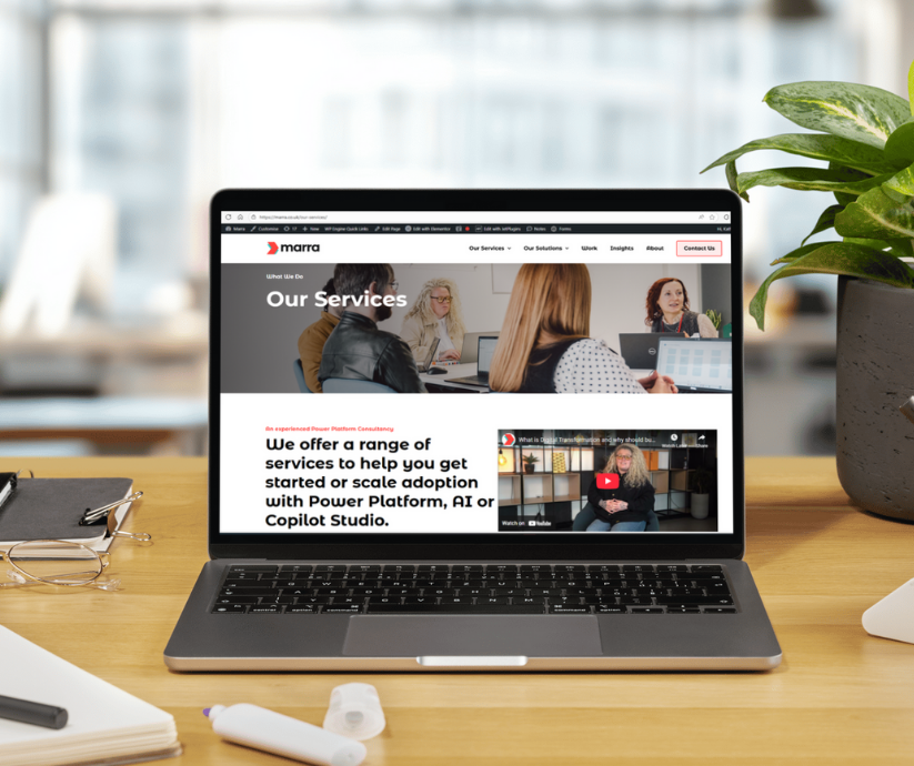 Laptop on a desk showing AI and copilot services landing page