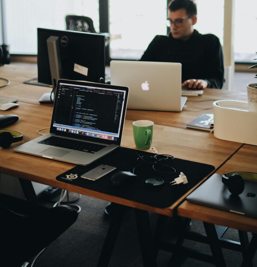 shared coworking desk with laptops on