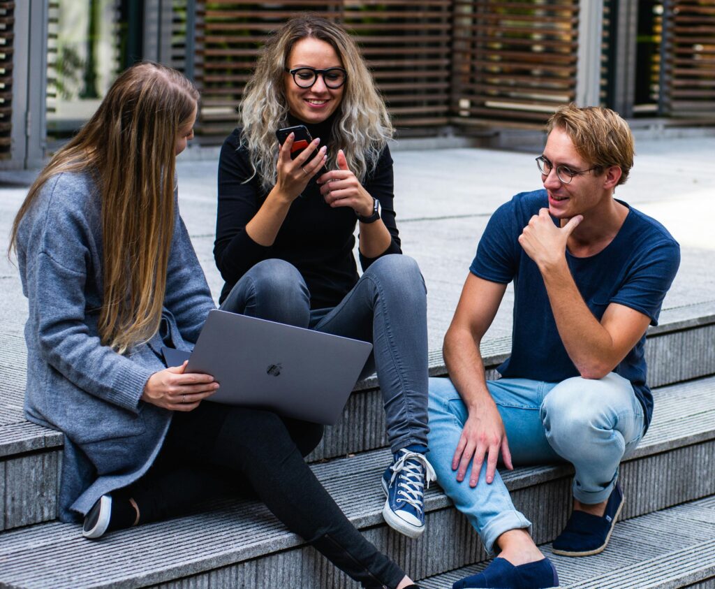 Three Persons Sitting on the Stairs Talking With Each Other