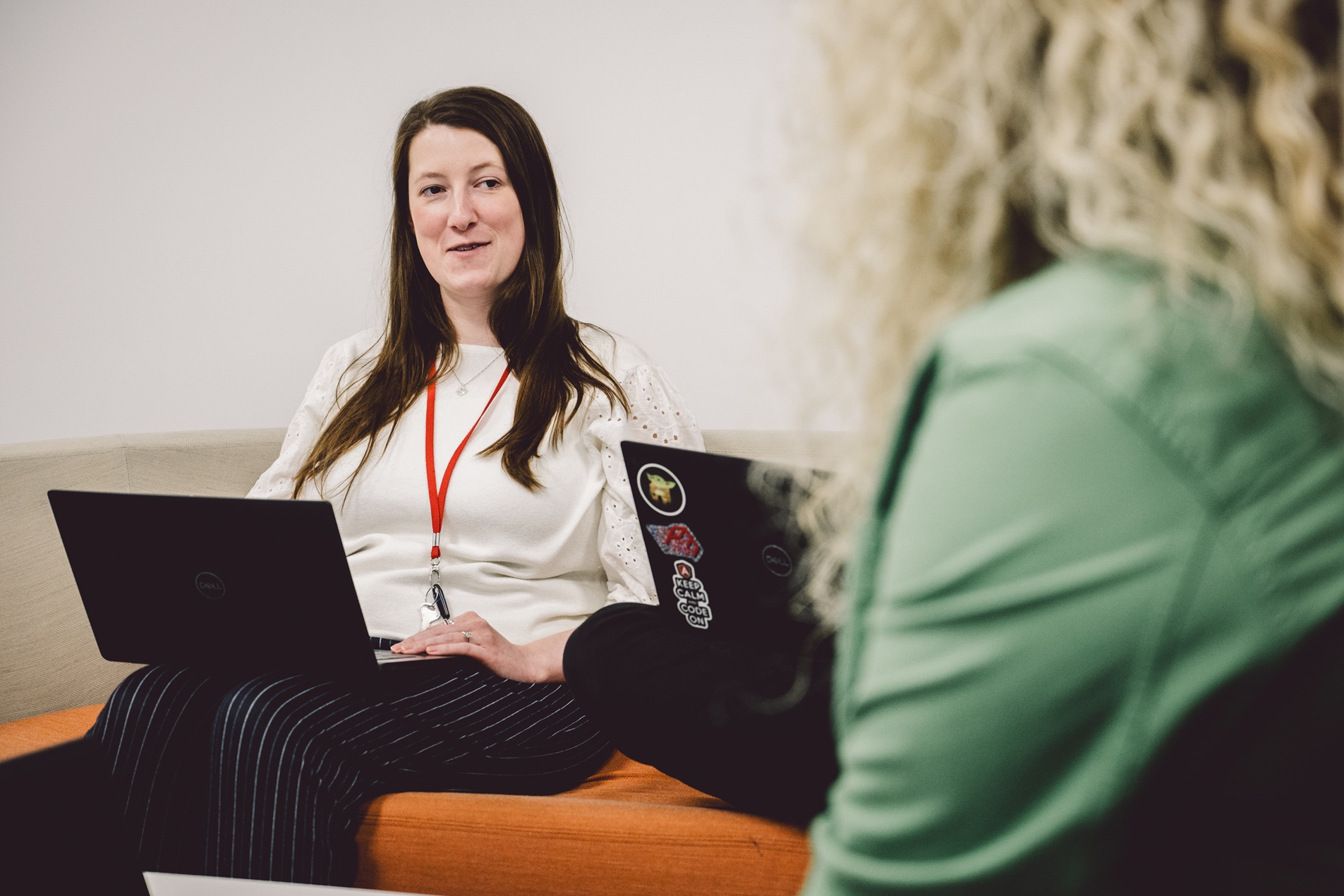 Two people discussing with laptops