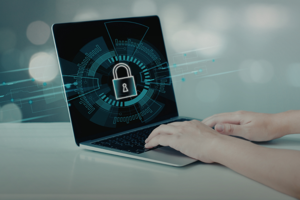 Person typing at a laptop with a security icon on the screen.